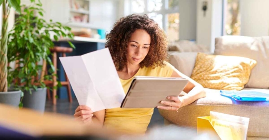 A woman reviewing financial documents in the comfort of her own home