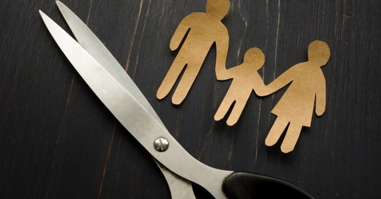 paper cut outs of family with a pair of scissors