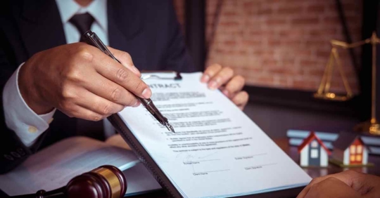 A person holding a piece of paper attached to a clipboard and a pen