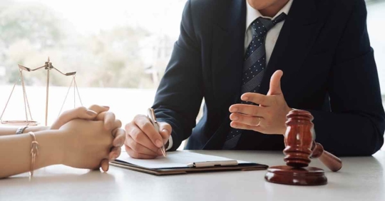 An attorney discussing a case with someone at their desk