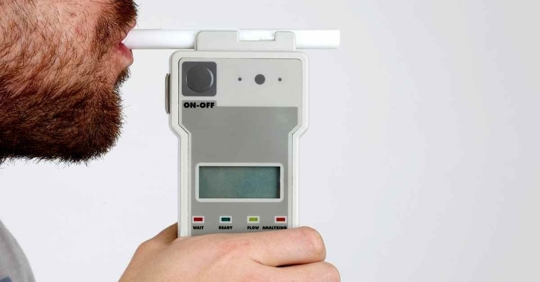 A man breathing into a breathalyzer