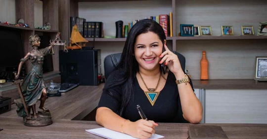 A female attorney taking notes while she talks on the phone