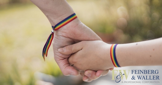 mom holding daughter's hand while wearing rainbow bracelets