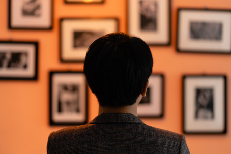 person looking at framed art on the wall