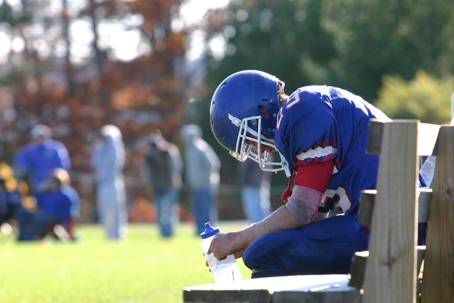 sad football player sitting on a bench
