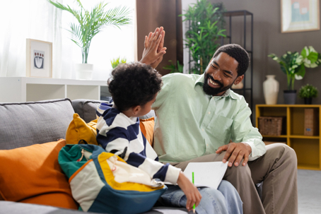 father and son high-fiving while doing homework